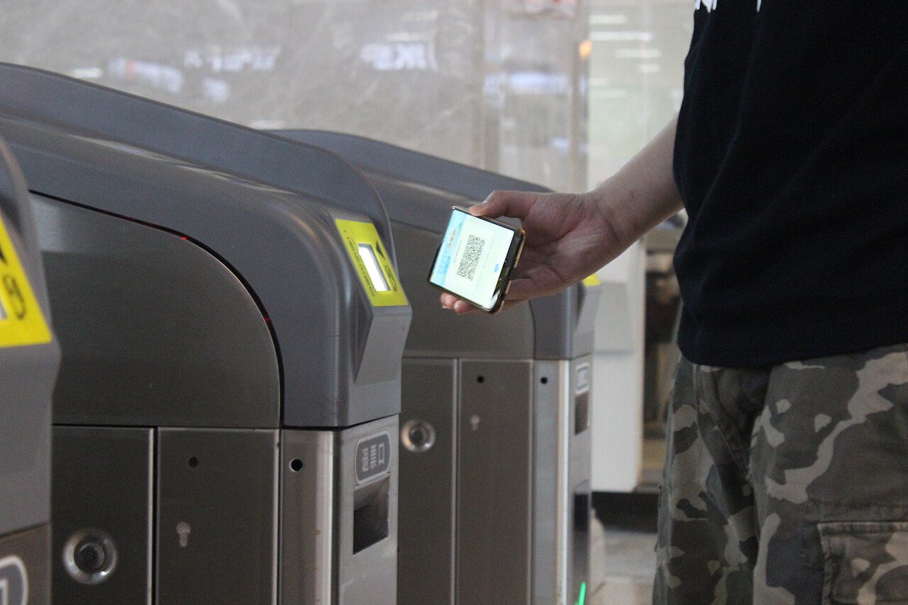 A metro fare gate opened by a phone QR code - scan with Alipay or WeChat Pay to pass, 3-8 yuan per ride