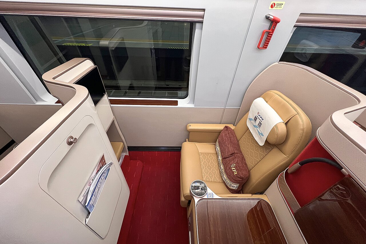 Business class seat on a CR400BF-S Fuxing train — a wide leather pod that reclines into a fully flat bed