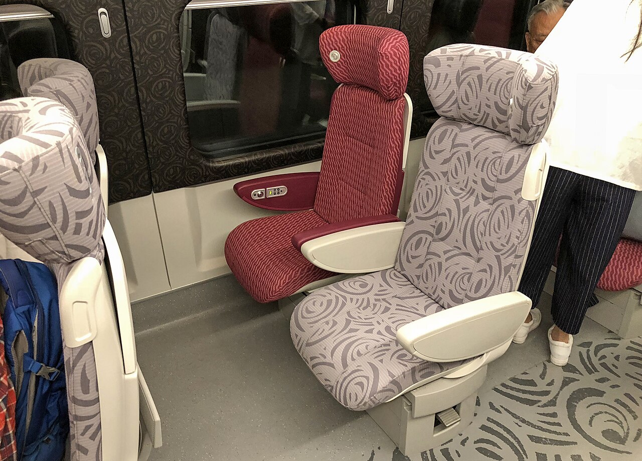 First class seat on a CRH380A train — a wider leather seat with generous legroom in a 2+2 layout