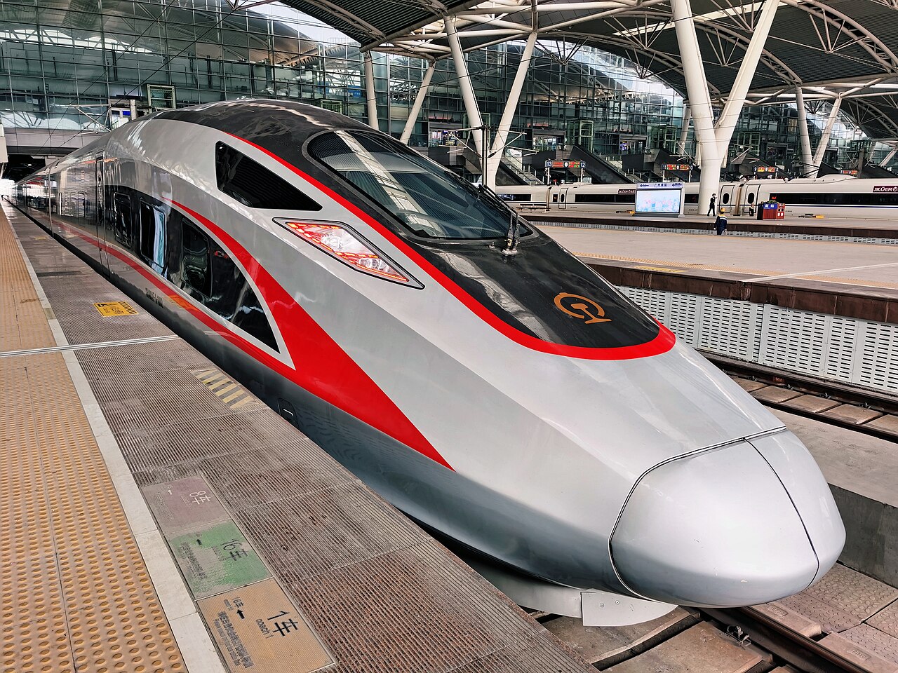 A CR400 Fuxing train — China's newest high-speed trains with a smooth shark-nose cab and red stripe, running at 350 km/h on flagship routes